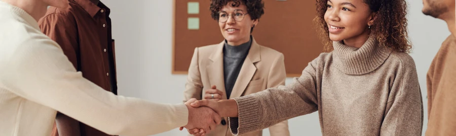 mlada_zena_podava_ruku_skupina_lidi